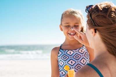 mom putting sunscreen on daughter